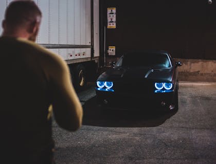 Um homem se aproximando de um carro e destrancando as portas com o controle.