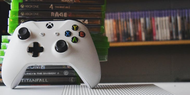 Xbox controller propped up against a stack of video games in a video game store.