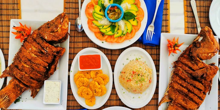 Caribbean food served on white plates in a Caribbean restaurant.