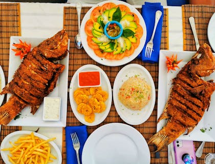 Comida caribenha servida em pratos brancos em restaurante caribenho.