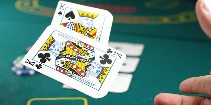 Card player throws a pair of kings on a casino table.