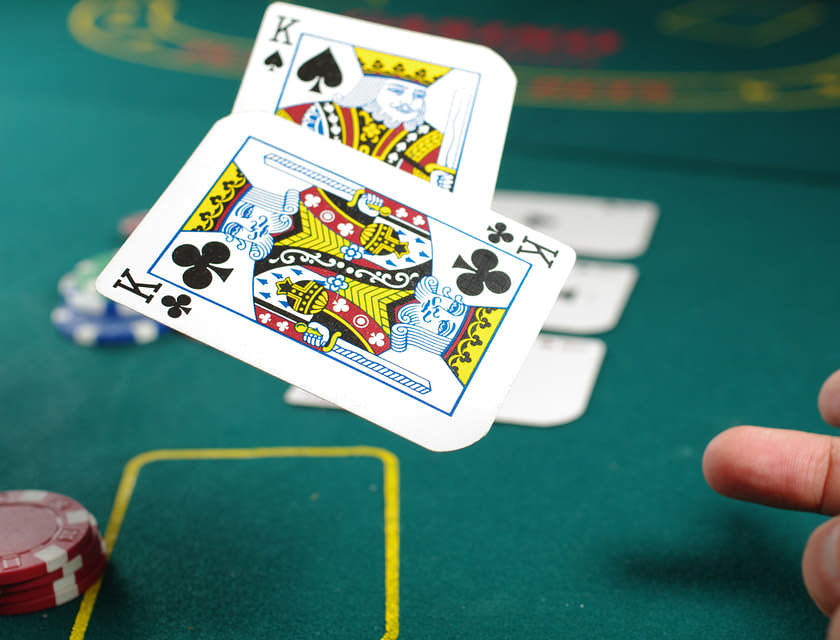 Ein Pokerspieler in einem Casino wirft ein Paar Könige auf den Spieltisch.
