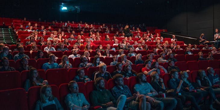 Rows of people watching a movie in a cinema.