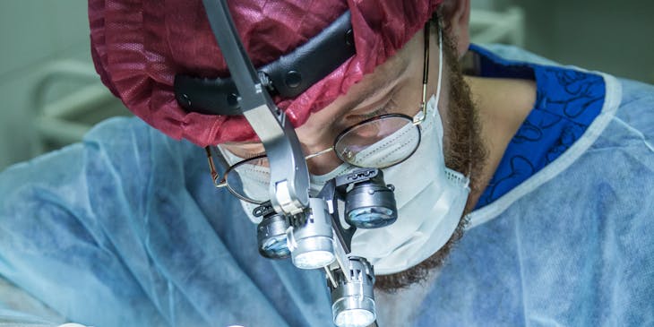 Surgeon performing a surgery in an operating room.
