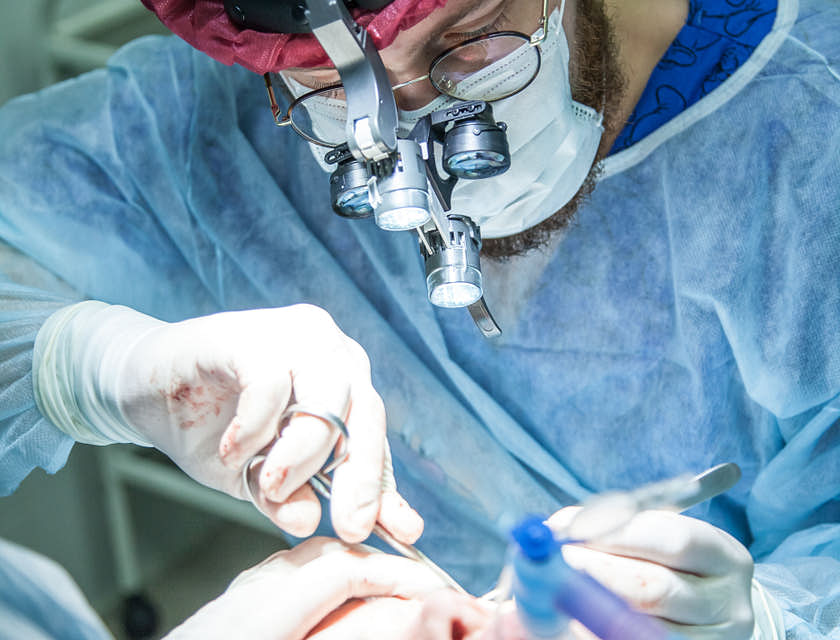 Surgeon performing a surgery in an operating room.