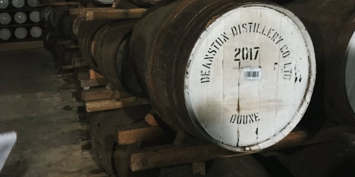 Oak barrels stored in a distillery cellar.