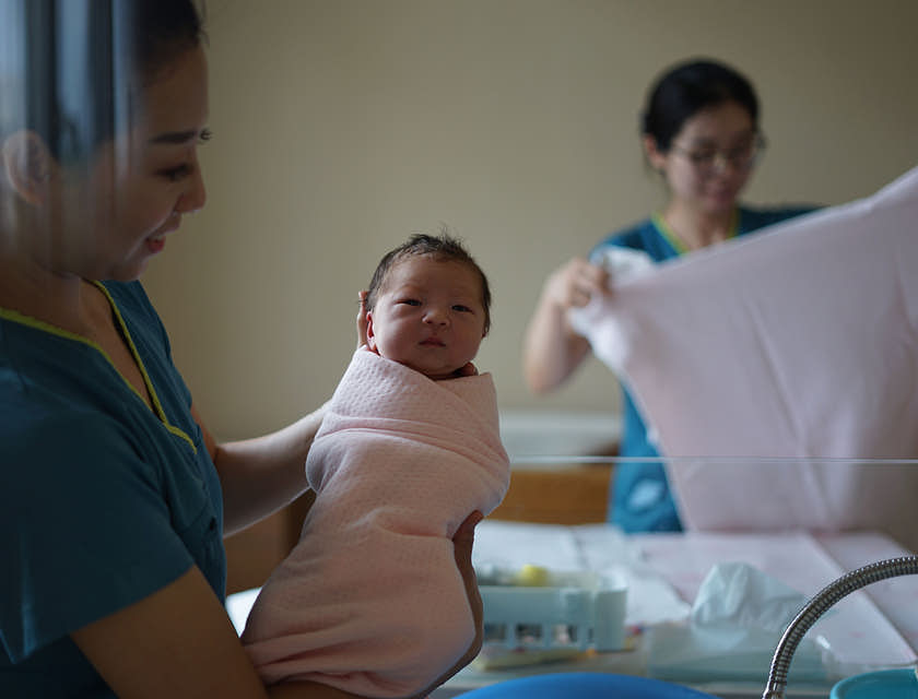 Una doula che tiene in braccio un bambino appena nato.