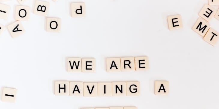 Lettere del gioco da tavolo "Scarabeo" che formano la frase Avremo un bambino.