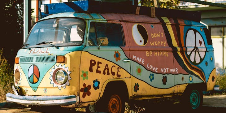 A hippie van covered in decorative hippie art.