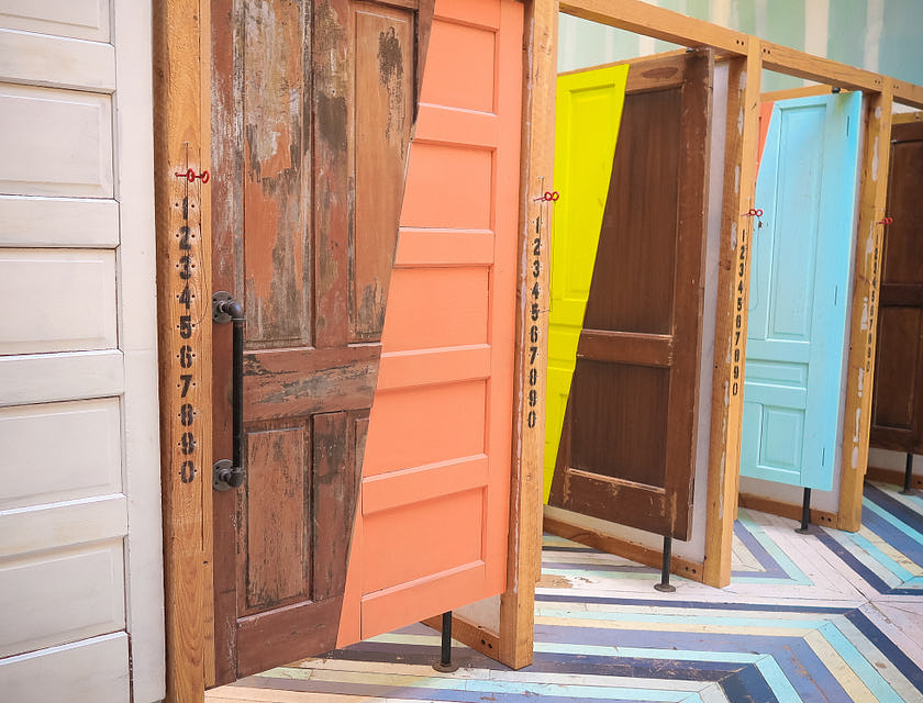 Une rangée intéressante et colorée de portes en bois partiellement ou entièrement peintes.