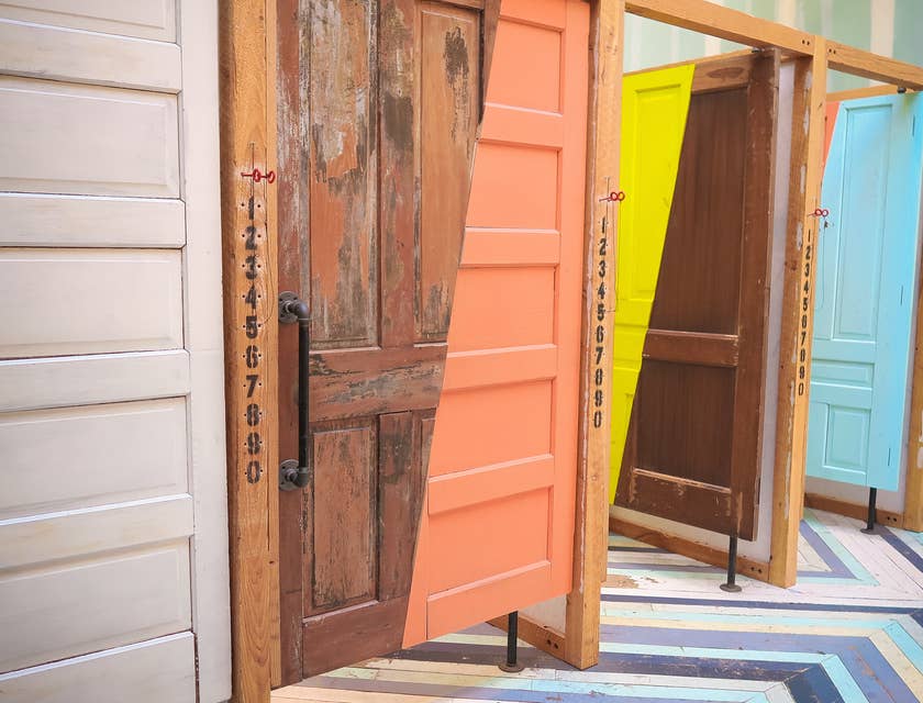 Uma fila de portas pintadas com cores interessantes e vibrantes.