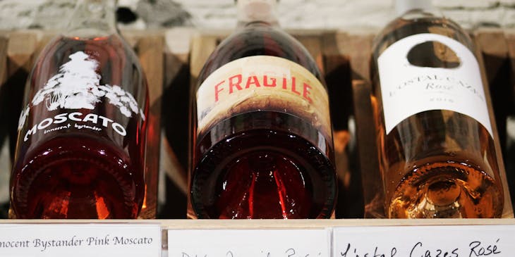Three bottles of liquor with corresponding, handwritten price tags.