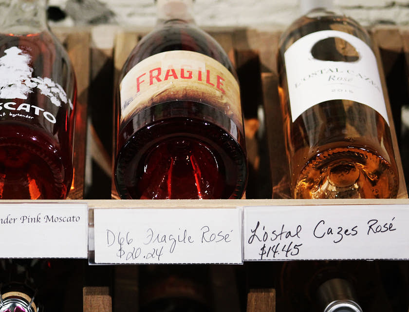 tre bottiglie di liquore e di vino esposte in un'enoteca