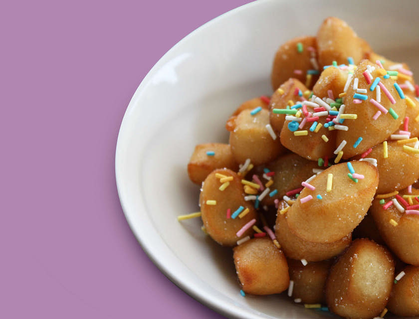 Una ciotola piena di struffoli comprati in una pasticceria napoletana.