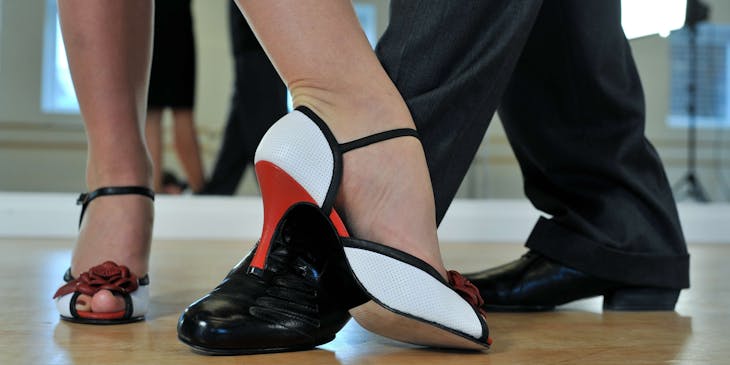 Dettaglio di piedi di una coppia che balla il tango in una balera.