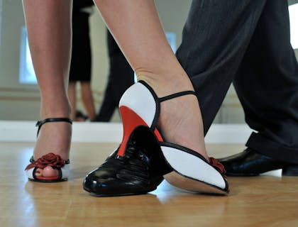 Dettaglio di piedi di una coppia che balla il tango in una balera.