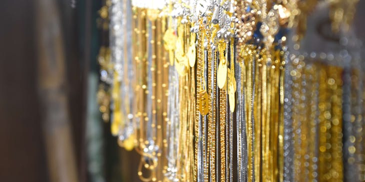 Tante collane d'oro e d'argento esposte in un compro oro.