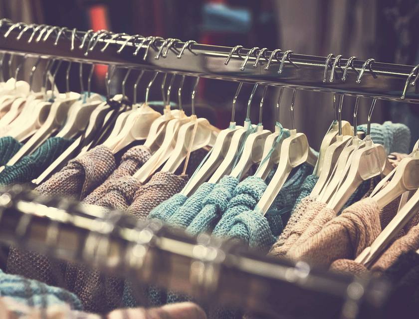Alcuni capi d'abbigliamento appesi a delle grucce in uno stand di un negozio di abbigliamento.