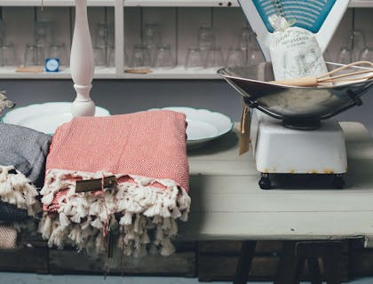 Delle tovaglie, dei bicchieri, dei piatti e delle fruste da cucina esposti in un negozio di articoli per la casa o casalinghi.