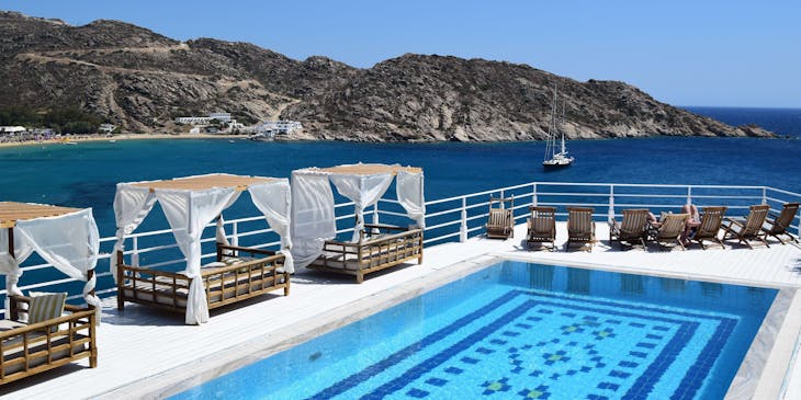 Una piscina con ombrelloni e sdraio sulla riva del mare.