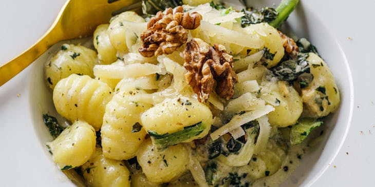 Gnocchi in a wide-rimmed pasta plate served in an Italian restaurant.