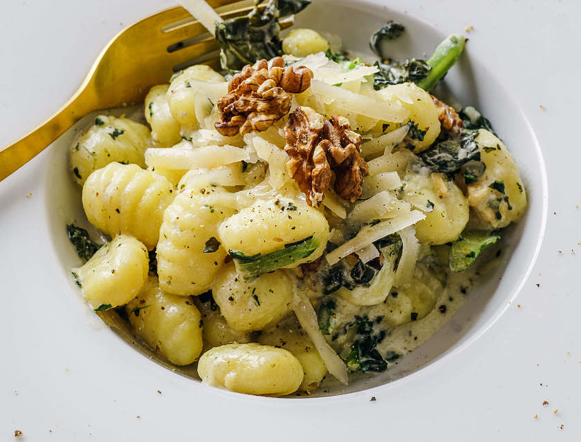 Gnocchi servido em um prato de borda larga em um restaurante italiano.