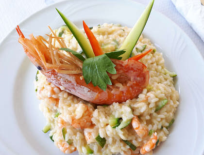 Risotto ai frutti di mare con verdure su un piatto bianco.