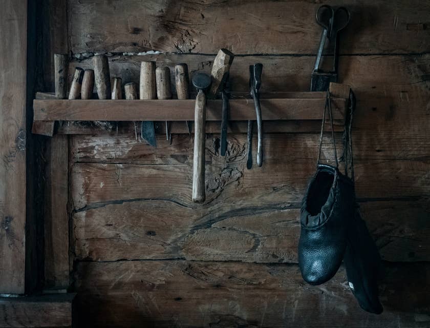 Vintage shoe repair tools hanging in a wooden shed.