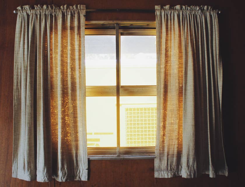 Des rideaux suspendus encadrant une fenêtre.