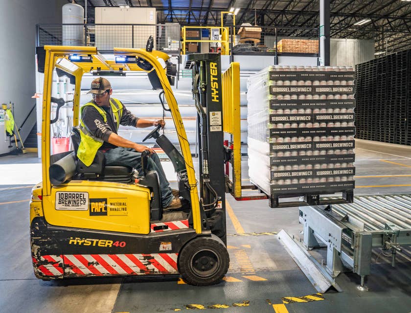 A person loading items using a forklift at a distribution company warehouse.