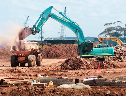 An earthmoving truck on a construction site being loaded with rubble for removal.