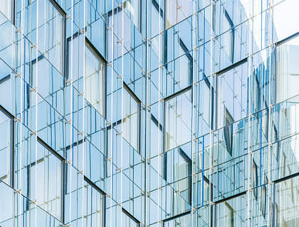 The exterior of a building coated in glass.