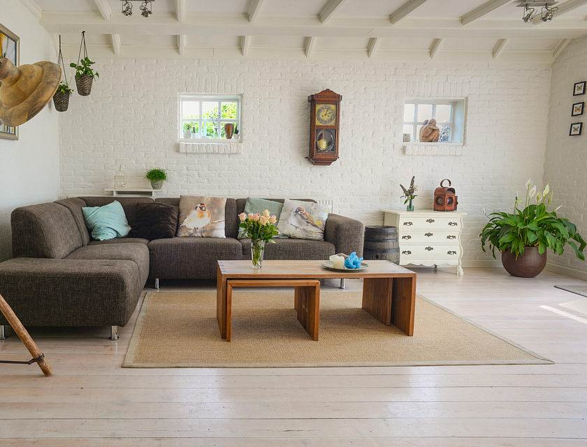 A brown sectional couch against a wall with a coffee table, light, and ornaments around it set up in a home store.