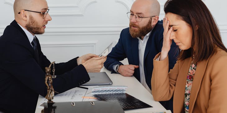 Lawyer speaking to two clients.