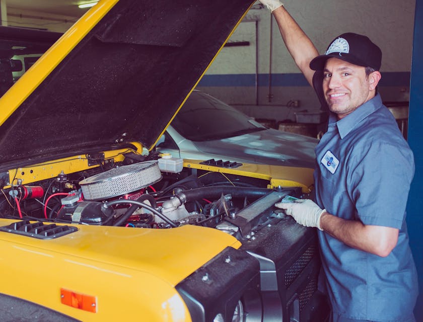 Um mecânico móvel abrindo o capô de um automóvel.