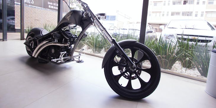 A chopper motorcycle on display in a motorcycle shop.