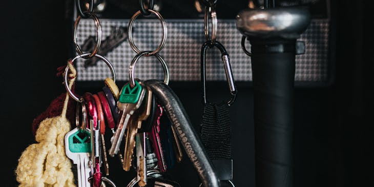 Various hanging keychains next to a self-defense bat.