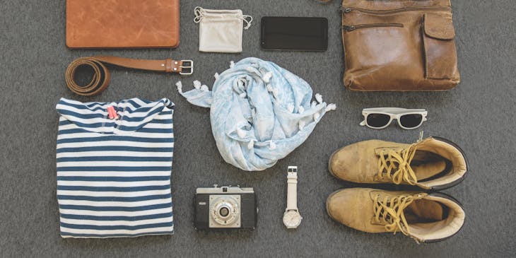 Several clothing items and accessories laid out on a flat surface.