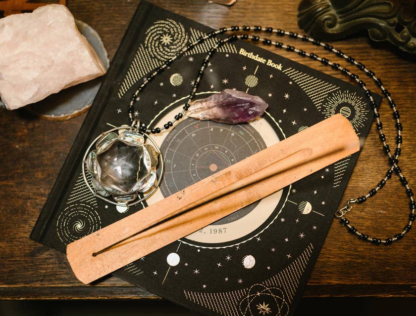 Livre des dates de naissance sur une table en bois sur laquelle sont posés des objets de sorcellerie.