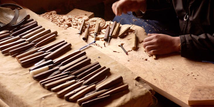 A skilled woodcraft tradesman creative a decorative wooden sculpture.