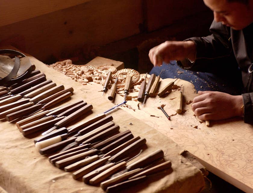 Um artesão criando uma escultura de madeira.