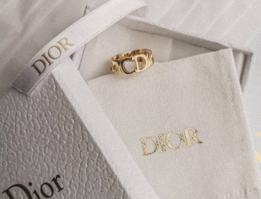 Une boîte à bijoux blanche portant le nom de la marque "Dior" en quatre lettres.