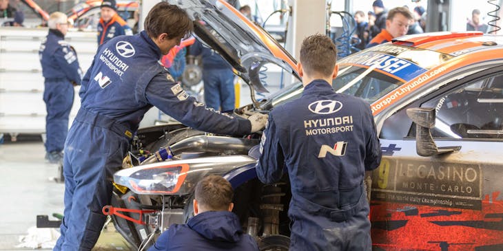 Alcuni carrozzieri che lavorano sulla carrozzeria di un'auto.