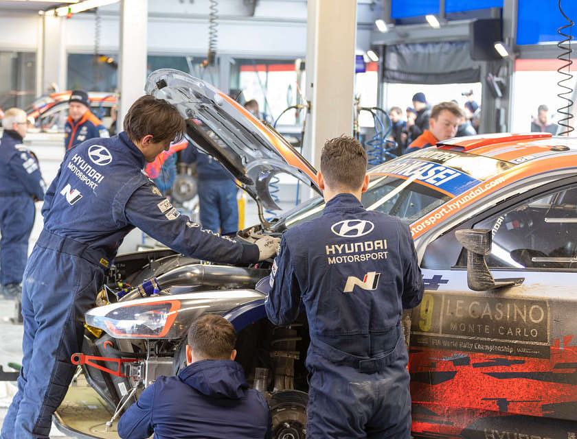 Alcuni carrozzieri che lavorano sulla carrozzeria di un'auto.