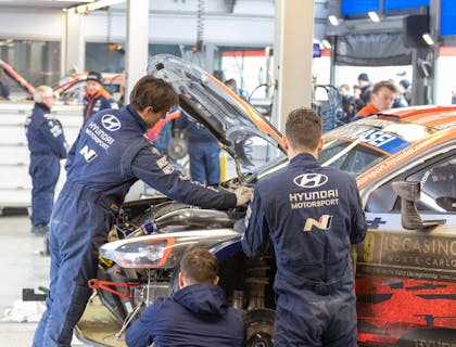 Alcuni carrozzieri che lavorano sulla carrozzeria di un'auto.