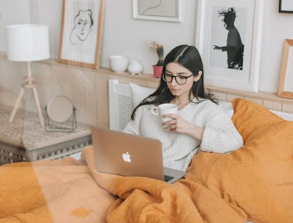Una ragazza che guarda una serie tv o un film in streaming su letto.