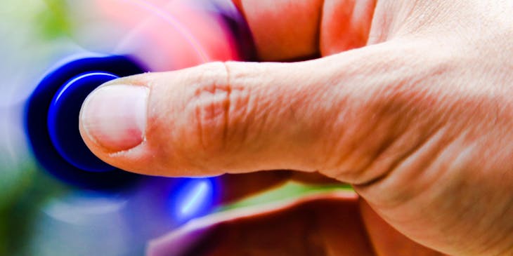 A close-up of a person's hand spinning a fidget toy.