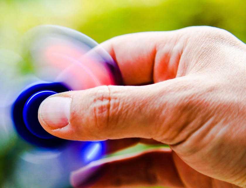 Um close-up da mão de uma pessoa brincando com um fidget toy.