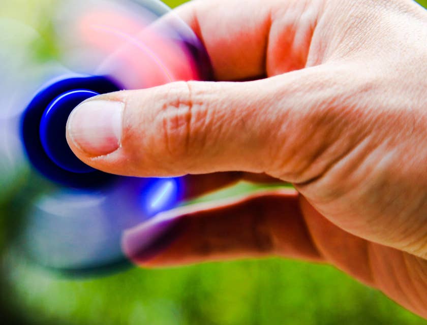 Um close-up da mão de uma pessoa brincando com um fidget toy.