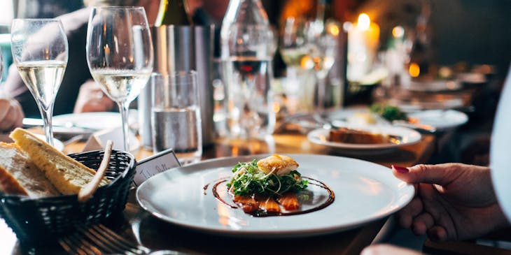 A plate of food sitting on a table at a gourmet restaurant.